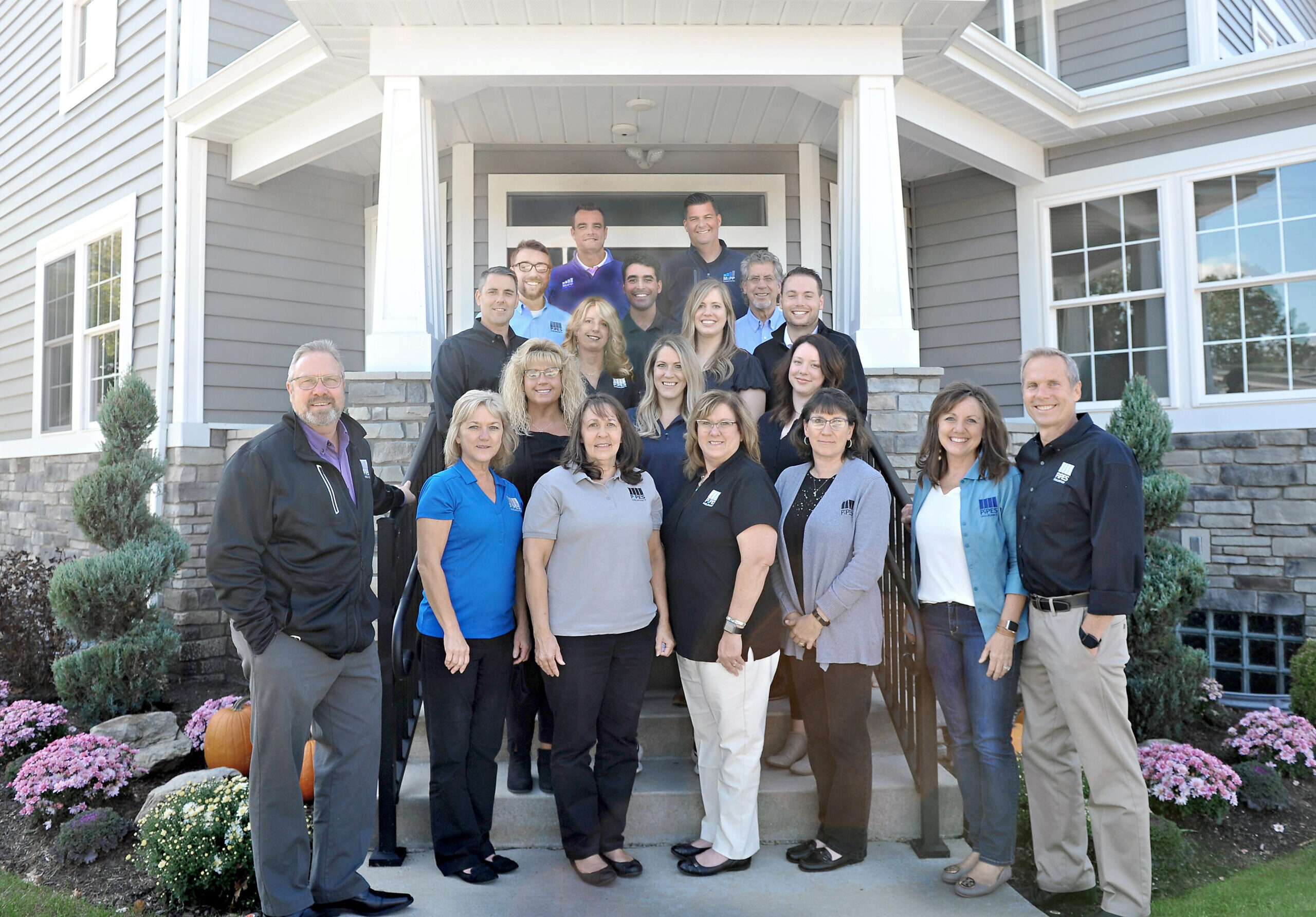 Picture of Pipes Insurance Service employees standing on front steps of office building smiling at the camera